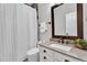 Bright bathroom featuring a shower-tub combo, a vessel sink with modern fixtures, and a framed vanity mirror at 2218 E Desert Trumpet Rd, Phoenix, AZ 85048