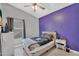 This bedroom features a modern ceiling fan, and a purple accent wall. Raiders fan, perhaps? at 2218 E Desert Trumpet Rd, Phoenix, AZ 85048