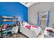 Cozy bedroom with a brightly painted accent wall and modern shelving above the desk at 2218 E Desert Trumpet Rd, Phoenix, AZ 85048