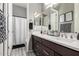 Well-lit bathroom features dual sinks, dark wood cabinets, and decorative wall art at 22434 S 226Th Pl, Queen Creek, AZ 85142