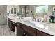 Bright bathroom with dual sinks, granite countertops, dark cabinetry, and tile flooring at 22434 S 226Th Pl, Queen Creek, AZ 85142