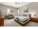Comfortable bedroom with large bed, accent chair, and modern ceiling fan at 22434 S 226Th Pl, Queen Creek, AZ 85142