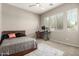 Bedroom with a large window, desk, and a comfortable queen-sized bed at 22434 S 226Th Pl, Queen Creek, AZ 85142