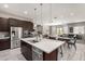 This kitchen flows into the dining and living area and features stainless appliances, a central island and pendant lighting at 22434 S 226Th Pl, Queen Creek, AZ 85142