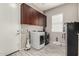 Laundry room with washer, dryer, overhead cabinets, and tile-look flooring at 22434 S 226Th Pl, Queen Creek, AZ 85142
