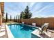 Backyard pool with seating, artificial turf, and privacy wall at 22434 S 226Th Pl, Queen Creek, AZ 85142