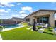 A well-manicured backyard featuring outdoor seating, a chiminea, and a pool, all on artificial grass at 22473 E Twilight Dr, Queen Creek, AZ 85142