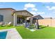 Inviting backyard with artificial grass, an outdoor seating area, chiminea, and a pool, for outdoor enjoyment at 22473 E Twilight Dr, Queen Creek, AZ 85142
