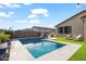 An inviting backyard featuring a pool with a lounge area, well-manicured artificial grass, and privacy fencing at 22473 E Twilight Dr, Queen Creek, AZ 85142