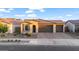 Charming single-story home with a two-car garage, brick driveway, and desert landscaping at 22473 E Twilight Dr, Queen Creek, AZ 85142