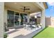 Cozy covered patio featuring a ceiling fan, sliding glass doors, dining table, and stylish outdoor rug at 22473 E Twilight Dr, Queen Creek, AZ 85142