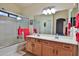 Well-lit bathroom featuring double sinks, wooden cabinets, and a shower-tub combo with sliding glass doors at 24721 W Dove Butte --, Buckeye, AZ 85326