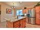Spacious kitchen with granite island, stainless steel fridge and tiled flooring at 24721 W Dove Butte --, Buckeye, AZ 85326