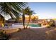 Gorgeous backyard pool area featuring palm trees, a rock waterfall, and ample space for outdoor relaxation at 24721 W Dove Butte --, Buckeye, AZ 85326