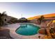 Backyard oasis boasts a pool with a rock waterfall feature, a hot tub and desert landscaping at 24721 W Dove Butte --, Buckeye, AZ 85326