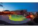 Stunning backyard pool with a rock waterfall and cozy gazebo, illuminated for a magical evening ambiance at 24721 W Dove Butte --, Buckeye, AZ 85326