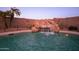 Stunning rock waterfall feature flows into a sparkling pool, surrounded by privacy landscaping at 24721 W Dove Butte --, Buckeye, AZ 85326