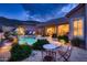 Backyard featuring a pebble patio, an outdoor cooking area, and a sparkling pool at 25929 N 84Th Ln, Peoria, AZ 85383