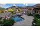 Lush backyard boasts a rock waterfall, fireplace, and seating against a mountain backdrop at 25929 N 84Th Ln, Peoria, AZ 85383