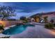 Inviting backyard with a rock pool and a stone fireplace creating a cozy outdoor oasis at 25929 N 84Th Ln, Peoria, AZ 85383