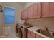 Well-equipped laundry room with modern washer, dryer, sink, and ample storage cabinets at 25929 N 84Th Ln, Peoria, AZ 85383