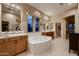Elegant bathroom features dual sinks, a large soaking tub, and bright natural light at 25929 N 84Th Ln, Peoria, AZ 85383