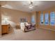 Spacious main bedroom featuring plush carpet, a ceiling fan, and an abundance of natural light from large windows at 25929 N 84Th Ln, Peoria, AZ 85383