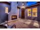 Cozy outdoor patio with brick pavers, fireplace, and comfortable seating, perfect for evening relaxation at 25929 N 84Th Ln, Peoria, AZ 85383
