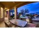Covered patio boasts comfortable seating, offering serene views of the pool, fireplace, and desert landscape at 25929 N 84Th Ln, Peoria, AZ 85383