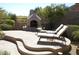 Inviting pool patio with a built-in fireplace and comfortable lounge chairs at 25929 N 84Th Ln, Peoria, AZ 85383