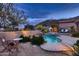 Inviting pool area with a cozy fireplace, lounge chairs, and mountain views, perfect for outdoor relaxation at 25929 N 84Th Ln, Peoria, AZ 85383