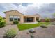The landscaped backyard features artificial turf, desert landscaping, and a covered patio, perfect for outdoor enjoyment at 26190 W Siesta Ln, Buckeye, AZ 85396