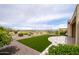 An expansive backyard features artificial turf, desert landscaping, and a stone patio with view of mountains at 26190 W Siesta Ln, Buckeye, AZ 85396
