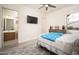 Cozy bedroom with mounted TV, ceiling fan and ensuite bathroom at 26190 W Siesta Ln, Buckeye, AZ 85396