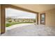 Covered patio featuring stone flooring with views of the landscaped backyard, a beautiful spot for outdoor living at 26190 W Siesta Ln, Buckeye, AZ 85396