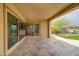 The covered patio features travertine flooring and access to the kitchen and landscaped backyard at 26190 W Siesta Ln, Buckeye, AZ 85396