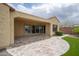 A view of covered patio leading to the backyard area with stone flooring, artificial turf, and manicured landscaping at 26190 W Siesta Ln, Buckeye, AZ 85396