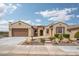 Charming, earth-toned home featuring a tile roof, arched entryway, and desert-friendly landscaping at 26190 W Siesta Ln, Buckeye, AZ 85396