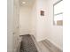 Hallway with neutral paint and wood-look floors leads to the front door at 26190 W Siesta Ln, Buckeye, AZ 85396
