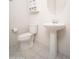 This powder room features a pedestal sink and a toilet with a tiled floor and a decorative cabinet at 26190 W Siesta Ln, Buckeye, AZ 85396
