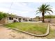 Spacious backyard with a pool, palm tree, well-maintained lawn, covered patio and a block fence at 2710 E Cinnabar Ave, Phoenix, AZ 85028