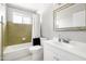 Bathroom featuring a sink with a decorative mirror, tub with white shower curtain, and tiled walls at 2710 E Cinnabar Ave, Phoenix, AZ 85028