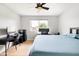 Bright bedroom featuring a ceiling fan, light wood floors, desk with dual monitors, and light blue bedding at 2710 E Cinnabar Ave, Phoenix, AZ 85028