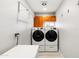 Bright laundry room features modern appliances and convenient folding rack and overhead cabinetry at 2710 E Cinnabar Ave, Phoenix, AZ 85028