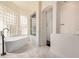 Bathroom featuring a walk-in shower, modern tub, and glass block window, offering a spa-like experience at 2732 E Hillery Dr, Phoenix, AZ 85032