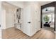 Hallway with stylish wood flooring leads to various rooms, including a glimpse of a bedroom and artwork at 2732 E Hillery Dr, Phoenix, AZ 85032