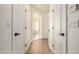 Bright hallway with wood floors and white doors, leading to sunlit rooms at 2732 E Hillery Dr, Phoenix, AZ 85032
