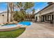 Backyard with a sparkling pool, mature palm trees, and rock features at 2732 E Hillery Dr, Phoenix, AZ 85032