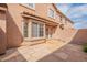 Backyard patio features durable stone tile, a brick fence, big windows and a door into the house, and bright sunlight at 2875 W Highland St # 1152, Chandler, AZ 85224