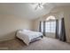 The primary bedroom has neutral colored walls, carpeted floor, a ceiling fan and large windows at 2875 W Highland St # 1152, Chandler, AZ 85224